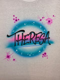 Original hand-airbrushed Theresa name artwork on white cotton, with black lettering, a teal ring, pink shading, purple stars and white highlights.