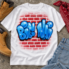 Styled digital mockup of a white shirt with Big Ni in blue dimensional graffiti lettering over red bricks, paired with stonewashed jeans, tan boots and a red bandana.
