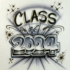 Class of 2024 airbrushed in dimensional silver-gray numbers with black lettering, swirls and starburst accents on a white shirt.