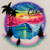 Clara script lettering above a tropical sunset, blue-green curling wave and palm silhouettes, with destination and year removed and natural color treatment.