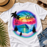 Clara sunset wave airbrush shirt styled on beach boardwalk wood with a straw hat, sunglasses and denim shorts; softly lit digital flatlay mockup.