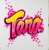 Tara in yellow-to-pink airbrush bubble script with black shadows, white highlights and magenta bubbles on white fabric.