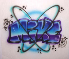 Mike hand-painted in blue, turquoise and purple graffiti letters with orbit-like loops, spiral stars and highlights on a white shirt.