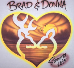 White buck-and-doe silhouettes meet inside an amber sunset heart edged in yellow. Your two names sit above in bold lettering. The Brad & Donna sample also shows a small Summer 2015 inscription.